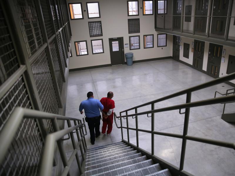 A guard escorts a detained immigrant from his "segregation cell" back into the general population at the Adelanto Detention Facility in November 2013. Today the privately run ICE facility in Adelanto, Calif., houses nearly 2,000 men and women and has come A guard escorts a detained immigrant from his "segregation cell" back into the general population at the Adelanto Detention Facility in November 2013. Today the privately run ICE facility in Adelanto, Calif., houses nearly 2,000 men and women and has come