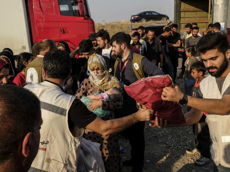Syrians fleeing the Turkish incursion in northeastern Syria receive bedding materials as they arrive at a camp in Dohuk, Iraq, on Thursday. Syrians fleeing the Turkish incursion in northeastern Syria receive bedding materials as they arrive at a camp in Dohuk, Iraq, on Thursday.