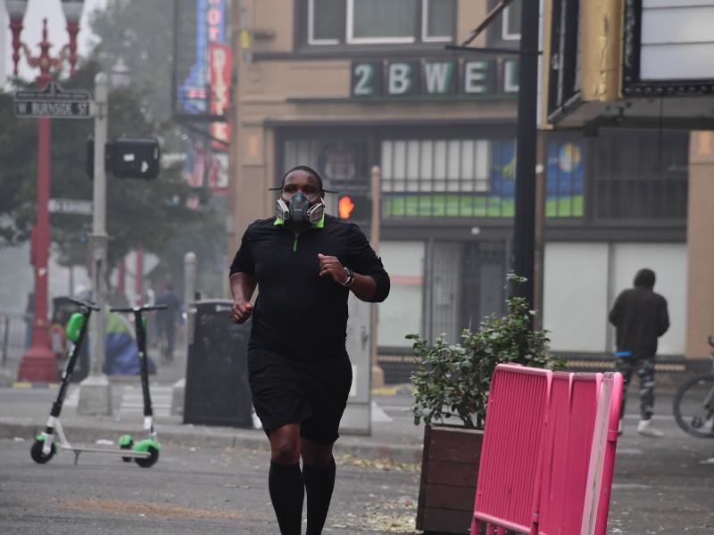 A Portland, Ore., resident wears a respirator to protect himself from wildfire smoke as he jogs in downtown in September 2020. A Portland, Ore., resident wears a respirator to protect himself from wildfire smoke as he jogs in downtown in September 2020.