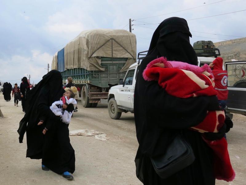 Women carry children near the al-Hol camp in Syria's Kurdish-majority region of Rojava. The camp is filled with more than 72,000 people — most of them women and children who came out of the last ISIS-held territory. Women carry children near the al-Hol camp in Syria's Kurdish-majority region of Rojava. The camp is filled with more than 72,000 people — most of them women and children who came out of the last ISIS-held territory.