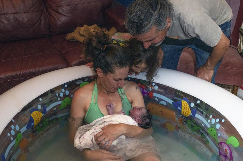 Morgan Cooper holds newborn Lourice as her husband Saleh Totah and 4-year-old son look on. Lourice was delivered in June in a home birth in an inflatable swimming pool in the family's home in the West Bank city of Ramallah. They planned to travel to the U Morgan Cooper holds newborn Lourice as her husband Saleh Totah and 4-year-old son look on. Lourice was delivered in June in a home birth in an inflatable swimming pool in the family's home in the West Bank city of Ramallah. They planned to travel to the U