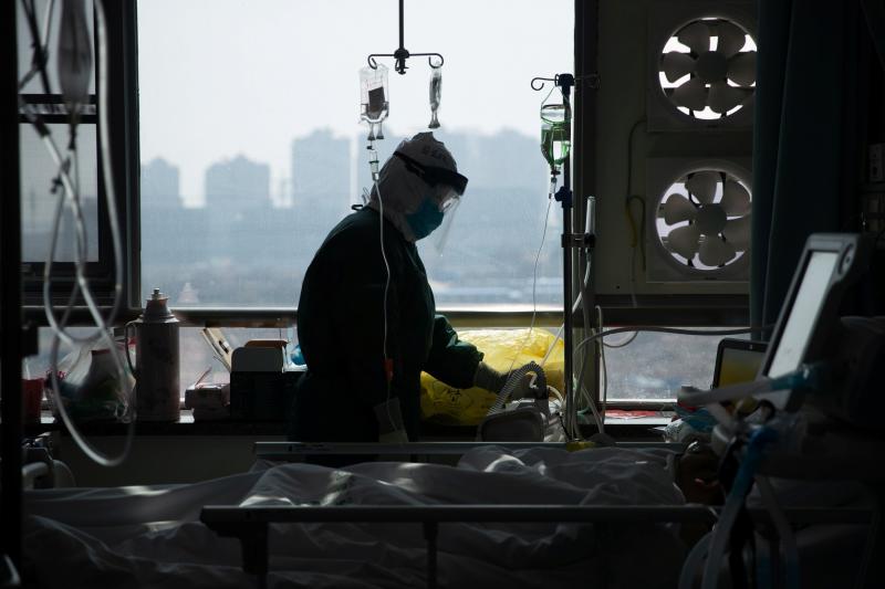 A medical worker in a protective suit tends to a patient in a hospital in Wuhan, China. A medical worker in a protective suit tends to a patient in a hospital in Wuhan, China.