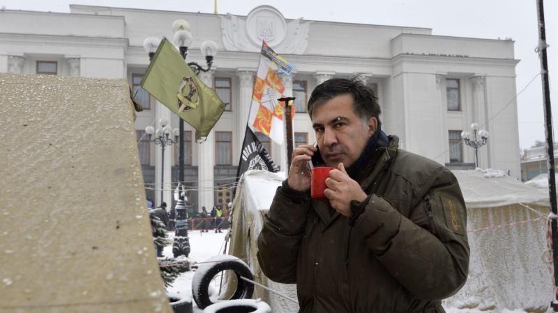 Former Georgian President Mikhail Saakashvili talks on a cellphone at a barricade in front of the Ukrainian Parliament in Kiev, where his supporters are camping. Former Georgian President Mikhail Saakashvili talks on a cellphone at a barricade in front of the Ukrainian Parliament in Kiev, where his supporters are camping.