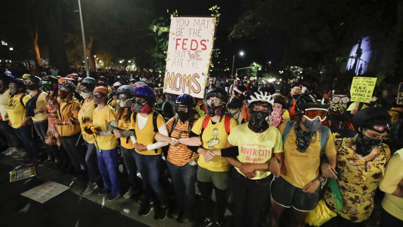 Members of the 'Wall of Moms" lock their arms during a Black Lives Matter protest at the Mark O. Hatfield United States Courthouse on Thursday in Portland, Ore. Members of the 'Wall of Moms" lock their arms during a Black Lives Matter protest at the Mark O. Hatfield United States Courthouse on Thursday in Portland, Ore.