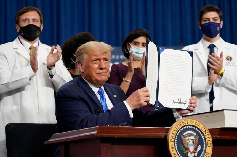 President Trump holds up an executive order after delivering remarks on health care in Charlotte, N.C., on Thursday. President Trump holds up an executive order after delivering remarks on health care in Charlotte, N.C., on Thursday.