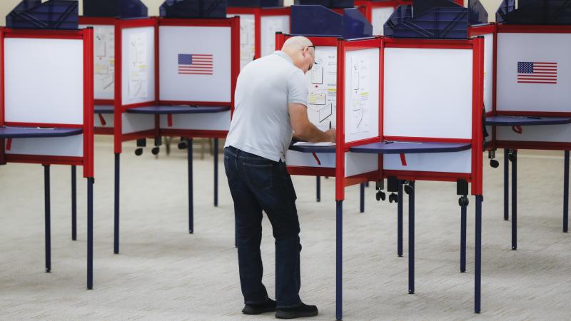 A voter fills out a ballot on the first day of early voting at the Hamilton County Board of Elections in Cincinnati last month. A voter fills out a ballot on the first day of early voting at the Hamilton County Board of Elections in Cincinnati last month.