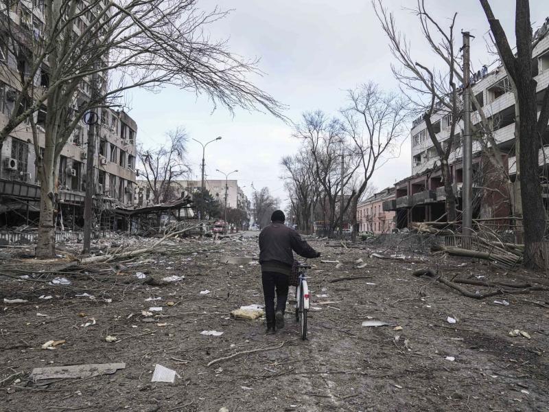 A man walks with a bicycle on a street damaged by shelling in Mariupol, Ukraine, earlier this month. A man walks with a bicycle on a street damaged by shelling in Mariupol, Ukraine, earlier this month.