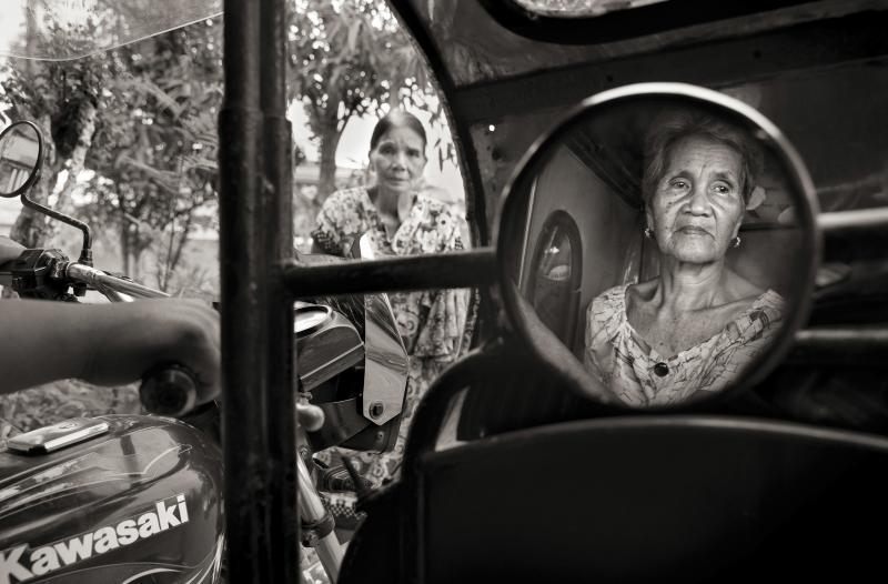 Isabelita Vinuya, 88, reflected in mirror, bids farewell to Perla Bulaon Balingit in the village of Mapaniqui in Pampanga. They are two of the last living "comfort women" of the Philippines. On Nov. 23, 1944, Vinuya, Balingit and some 100 other girls and Isabelita Vinuya, 88, reflected in mirror, bids farewell to Perla Bulaon Balingit in the village of Mapaniqui in Pampanga. They are two of the last living "comfort women" of the Philippines. On Nov. 23, 1944, Vinuya, Balingit and some 100 other girls and