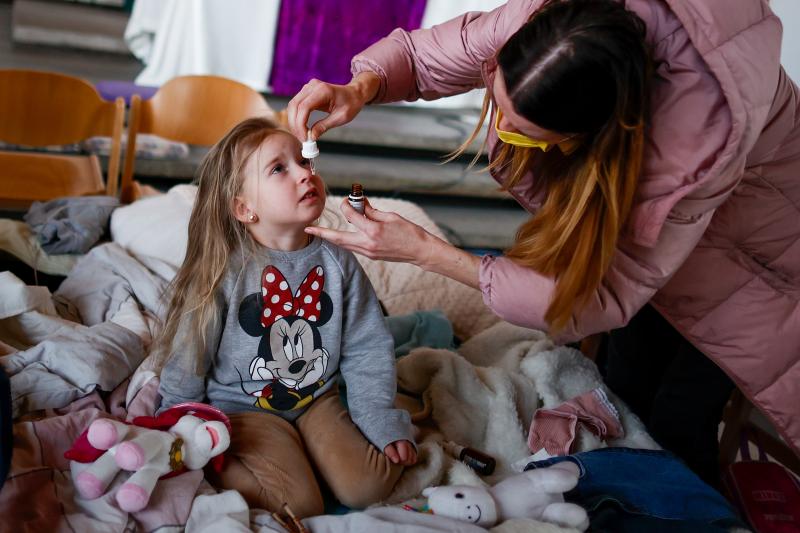 Ukrainian refugee Alina Archipova gives her daughter medication at a temporary shelter in Berlin, Germany, on March 10. Ukrainian refugee Alina Archipova gives her daughter medication at a temporary shelter in Berlin, Germany, on March 10.