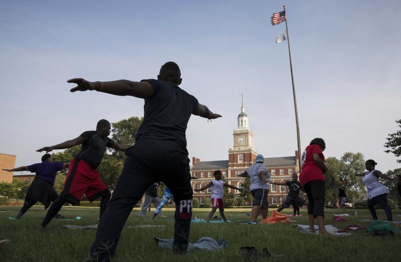 Participants stretch during a "yoga on the yard" class, one of Howard University's sesquicentennial celebration events that was open to anyone who wanted to attend in Washington, D.C. The university is trying to foster better communication with the surrou Participants stretch during a "yoga on the yard" class, one of Howard University's sesquicentennial celebration events that was open to anyone who wanted to attend in Washington, D.C. The university is trying to foster better communication with the surrou