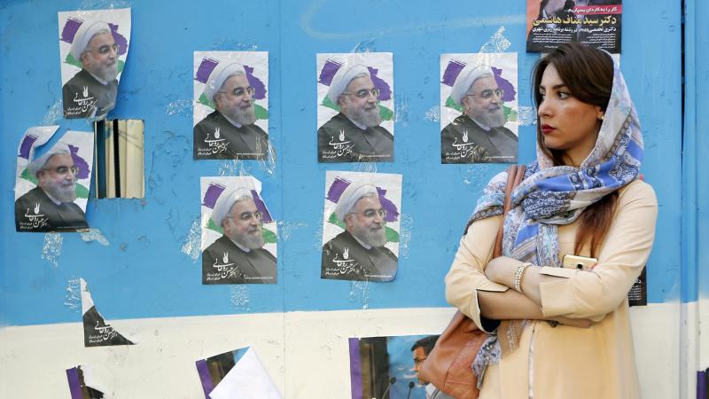 A woman in Tehran stands in front of a wall plastered with posters of Iranian President Hassan Rouhani, whose re-election bid will have its decisive moment Friday — unless, of course, the voting results in a runoff. A woman in Tehran stands in front of a wall plastered with posters of Iranian President Hassan Rouhani, whose re-election bid will have its decisive moment Friday — unless, of course, the voting results in a runoff.