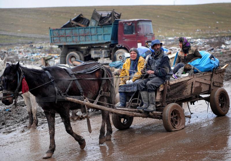 A Roma family rides a horse-drawn cart carrying scrap metal out of Romania's Pata-Rât city dump. A Roma family rides a horse-drawn cart carrying scrap metal out of Romania's Pata-Rât city dump.