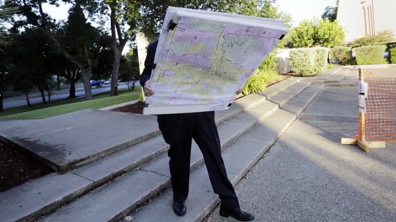 A man with a set of maps heads to a federal courthouse in San Antonio last year for a redistricting trial. Texas is one of three states with cases before the Supreme Court in redistricting. A man with a set of maps heads to a federal courthouse in San Antonio last year for a redistricting trial. Texas is one of three states with cases before the Supreme Court in redistricting.