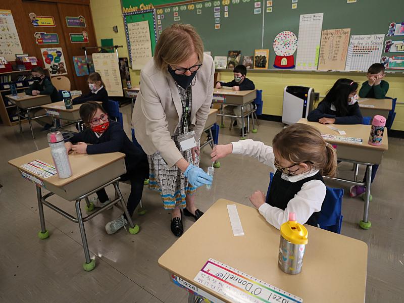 A student gives her coronavirus swab to Helenann Civian, the principal of South Boston Catholic Academy in Boston in January. The White House announced $10 billion to expand testing in K-12 schools. A student gives her coronavirus swab to Helenann Civian, the principal of South Boston Catholic Academy in Boston in January. The White House announced $10 billion to expand testing in K-12 schools.