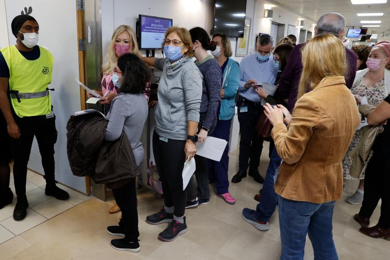 Staff volunteers queue to receive a fourth dose of the Pfizer COVID-19 vaccine at Sheba Medical Center in Israel on Dec. 27, 2021, as the hospital conducted a trial of a fourth jab of the vaccine. Staff volunteers queue to receive a fourth dose of the Pfizer COVID-19 vaccine at Sheba Medical Center in Israel on Dec. 27, 2021, as the hospital conducted a trial of a fourth jab of the vaccine.