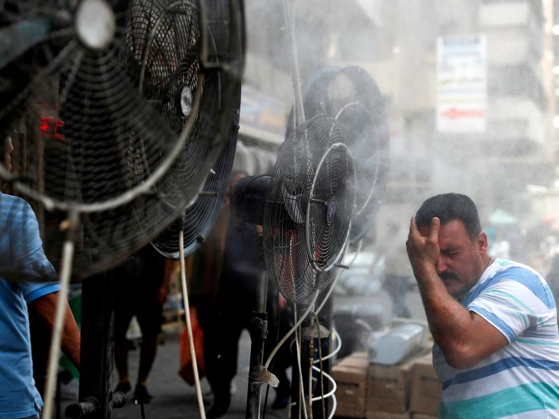 Fans spray air mixed with water vapor to cool down pedestrians on a Baghdad street on June 30, 2021, during a heat wave. Fans spray air mixed with water vapor to cool down pedestrians on a Baghdad street on June 30, 2021, during a heat wave.