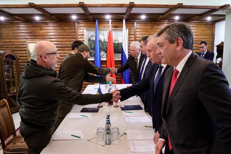 Ukrainian Defense Minister Oleksii Reznikov (left) shakes hands with Russian negotiators prior to talks between their countries' delegations amid Russia's invasion of Ukraine, in Belarus' Brest region on March 3. Ukrainian Defense Minister Oleksii Reznikov (left) shakes hands with Russian negotiators prior to talks between their countries' delegations amid Russia's invasion of Ukraine, in Belarus' Brest region on March 3.
