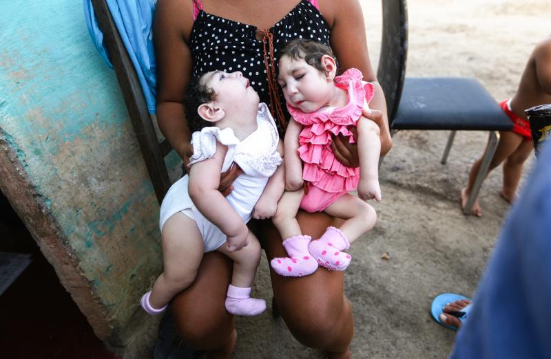A family member holds twins Eloisa (left) and Eloa, both 8 months old and born with microcephaly, during a Christmas gathering. The mother of the twins, Raquel, who lives in Brazil, said she contracted Zika during her pregnancy. A family member holds twins Eloisa (left) and Eloa, both 8 months old and born with microcephaly, during a Christmas gathering. The mother of the twins, Raquel, who lives in Brazil, said she contracted Zika during her pregnancy.