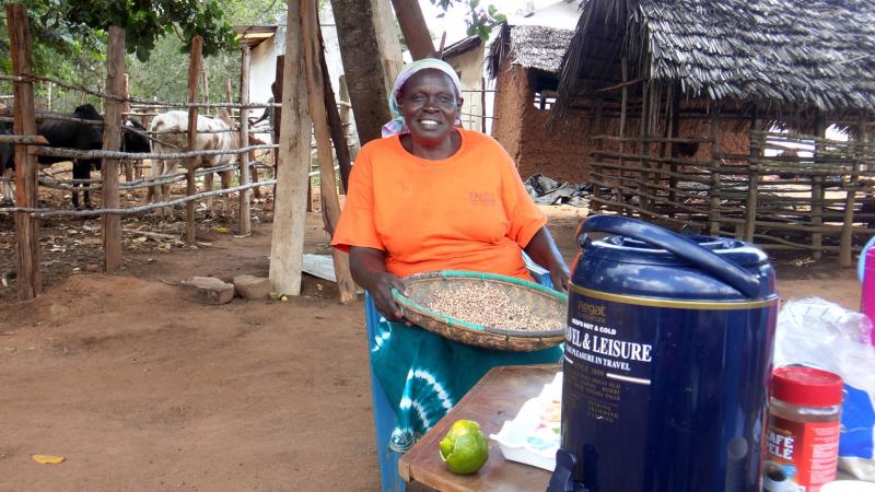 Bertha Ngumbi, mother of five children who are all now grown, at her farm in Kenya. She's sifting through beans to get rid of bad ones and stones. The cows' and goats' houses are behind her. Bertha Ngumbi, mother of five children who are all now grown, at her farm in Kenya. She's sifting through beans to get rid of bad ones and stones. The cows' and goats' houses are behind her.