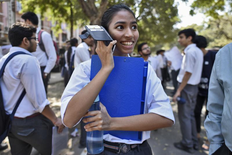 A girl talks on her mobile phone after coming out of class in New Delhi. A girl talks on her mobile phone after coming out of class in New Delhi.