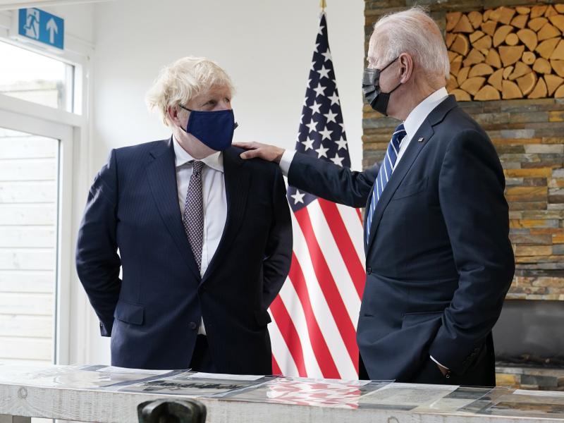 British Prime Minister Boris Johnson and President Biden talk Thursday during a meeting in Carbis Bay, England, as they look over copies of the original Atlantic Charter from 1941. British Prime Minister Boris Johnson and President Biden talk Thursday during a meeting in Carbis Bay, England, as they look over copies of the original Atlantic Charter from 1941.