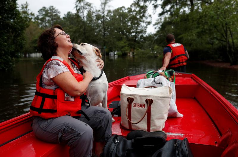 Susan Hedgpeth hugs her dog Cooper Sunday as they go to higher ground via the U.S. Coast Guard in Lumberton, N.C. Susan Hedgpeth hugs her dog Cooper Sunday as they go to higher ground via the U.S. Coast Guard in Lumberton, N.C.