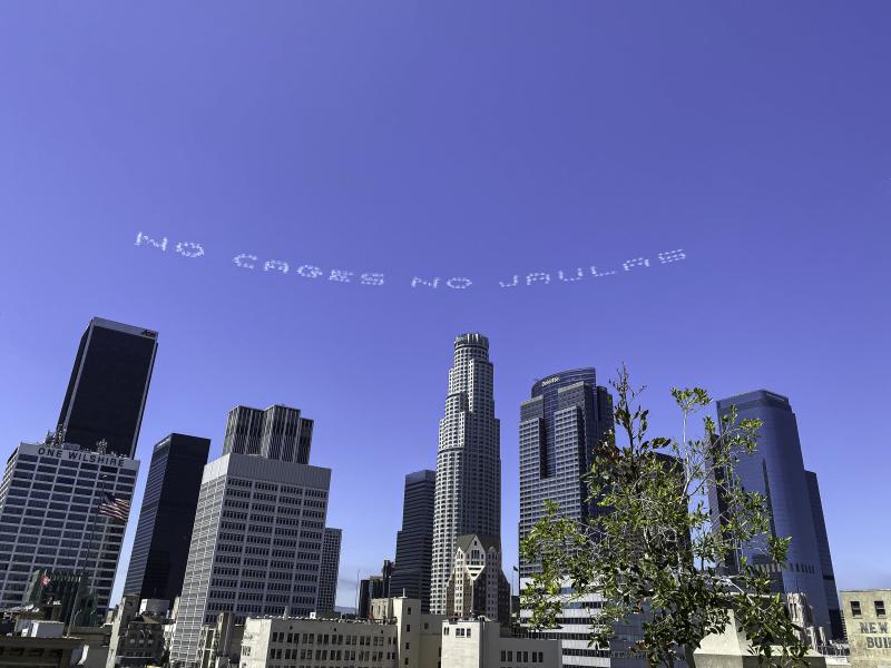 The words "No Cages No Jaulas" appear over downtown Los Angeles as part of a day of activism by artists nationwide to mark the July 4 holiday. The message was designed by the artist Beatriz Cortez. The words "No Cages No Jaulas" appear over downtown Los Angeles as part of a day of activism by artists nationwide to mark the July 4 holiday. The message was designed by the artist Beatriz Cortez.