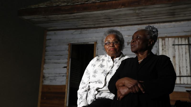 Emily Meggett (left) and Isabell Meggett Lucas sit together at the National Museum of African American History and Culture in front of a slave cabin on display that they grew up in. Emily Meggett (left) and Isabell Meggett Lucas sit together at the National Museum of African American History and Culture in front of a slave cabin on display that they grew up in.