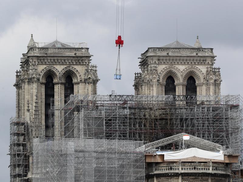 A box hangs from a crane at Notre Dame cathedral on Monday. Officials said they hope to hold Mass in the cathedral by 2024, when the city is set to host the Olympic games. A box hangs from a crane at Notre Dame cathedral on Monday. Officials said they hope to hold Mass in the cathedral by 2024, when the city is set to host the Olympic games.
