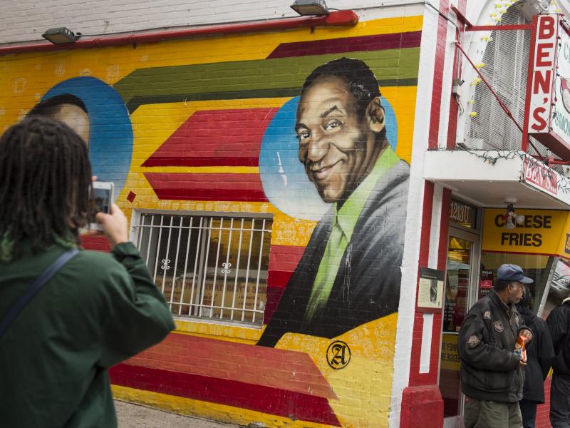 People walk past a mural of comedian Bill Cosby on the side of Ben's Chili Bowl restaurant in Washington, D.C., Dec. 31, 2015. People walk past a mural of comedian Bill Cosby on the side of Ben's Chili Bowl restaurant in Washington, D.C., Dec. 31, 2015.
