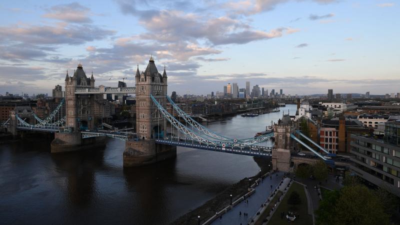 Tower Bridge over The River Thames and, in the distance, the secondary central business district of Canary Wharf are pictured as the sun sets in London. Tower Bridge over The River Thames and, in the distance, the secondary central business district of Canary Wharf are pictured as the sun sets in London.