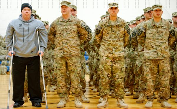 As part of homecoming ceremonies at Joint Base Lewis-McChord in Washington state in January, Army Spc. Tyler Jeffries — with crutches and prosthetic legs — joins his unit in formation as the national anthem is played. The homecoming marked the first t As part of homecoming ceremonies at Joint Base Lewis-McChord in Washington state in January, Army Spc. Tyler Jeffries — with crutches and prosthetic legs — joins his unit in formation as the national anthem is played. The homecoming marked the first t