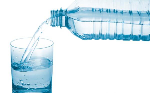 Water pouring from a bottle into a glass. Water pouring from a bottle into a glass.