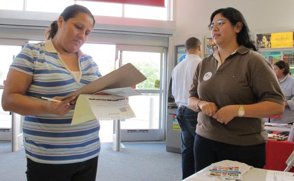 Enroll America outreach worker Rosy Mota (right) talks about the federal health care law with a CVS customer. Enroll America outreach worker Rosy Mota (right) talks about the federal health care law with a CVS customer.