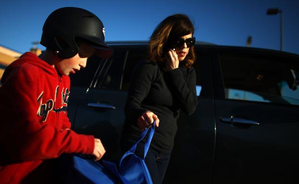 Yvonne Condes helps her son Alec get ready for baseball practice. Yvonne Condes helps her son Alec get ready for baseball practice.