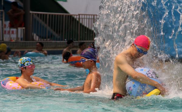 People cool off Wednesday in a pool in Shanghai, where temperatures reached an all-time record: 105.4 degrees. People cool off Wednesday in a pool in Shanghai, where temperatures reached an all-time record: 105.4 degrees.