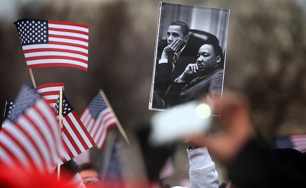A spectator on the National Mall holds an image of President Obama and Martin Luther King during the 2013 presidential inauguration in January. A spectator on the National Mall holds an image of President Obama and Martin Luther King during the 2013 presidential inauguration in January.