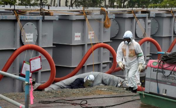 Tokyo Electric Power Co (TEPCO) workers work on waste water tanks at Japan's Fukushima Daiichi nuclear plant in the town of Okuma, Fukushima prefecture in Japan on June 12, 2013. Tokyo Electric Power Co (TEPCO) workers work on waste water tanks at Japan's Fukushima Daiichi nuclear plant in the town of Okuma, Fukushima prefecture in Japan on June 12, 2013.