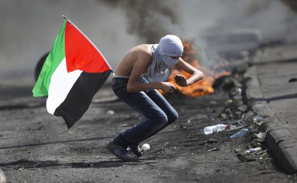 A Palestinian tries to dodge rubber coated bullets during clashes with Israeli troops near Ramallah, West Bank, on Tuesday. A Palestinian tries to dodge rubber coated bullets during clashes with Israeli troops near Ramallah, West Bank, on Tuesday.