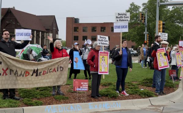 Advocates for expanding Medicaid in Kansas staged a protest outside the entrance to the statehouse parking garage in Topeka in May 2019. Today, twelve states have still not expanded Medicaid. The biggest are Texas, Florida, and Georgia, but there are a fe Advocates for expanding Medicaid in Kansas staged a protest outside the entrance to the statehouse parking garage in Topeka in May 2019. Today, twelve states have still not expanded Medicaid. The biggest are Texas, Florida, and Georgia, but there are a fe