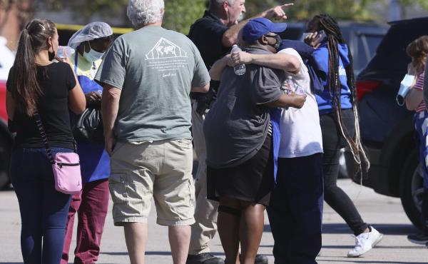 People embrace as police respond to the scene of a shooting at a Kroger grocery store in Collierville, Tenn., on Thursday. Police say 13 people were injured, one of whom has died. The suspected shooter also died from what police say was a self-inflicted g People embrace as police respond to the scene of a shooting at a Kroger grocery store in Collierville, Tenn., on Thursday. Police say 13 people were injured, one of whom has died. The suspected shooter also died from what police say was a self-inflicted g