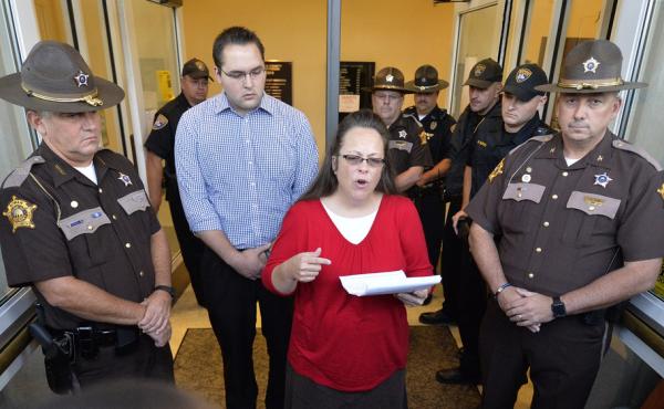 Surrounded by sheriff's deputies, Rowan County Clerk Kim Davis, with her son Nathan Davis standing by her side, makes a statement to the media Monday at the front door of the county Judicial Center in Morehead, Ky. Surrounded by sheriff's deputies, Rowan County Clerk Kim Davis, with her son Nathan Davis standing by her side, makes a statement to the media Monday at the front door of the county Judicial Center in Morehead, Ky.