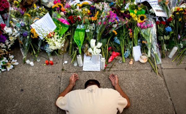 Raymond Smith of Charleston, S.C., kneels in prayer in front of the Emanuel AME Church in Charleston before a worship service on June 21. Raymond Smith of Charleston, S.C., kneels in prayer in front of the Emanuel AME Church in Charleston before a worship service on June 21.