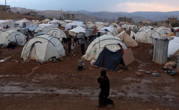 A Syrian refuge woman walks past tents at a refugee camp in the eastern Lebanese border town of Arsal, Lebanon, Monday, Nov. 18, 2013. A Syrian refuge woman walks past tents at a refugee camp in the eastern Lebanese border town of Arsal, Lebanon, Monday, Nov. 18, 2013.
