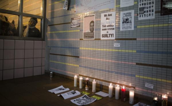 A demonstrator peers at a memorial to Akai Gurley at a public housing complex in Brooklyn, N.Y. Gurley was shot and killed by an NYPD officer in November 2014. A demonstrator peers at a memorial to Akai Gurley at a public housing complex in Brooklyn, N.Y. Gurley was shot and killed by an NYPD officer in November 2014.