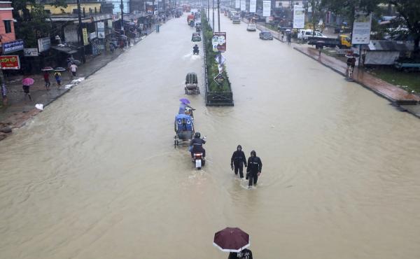 People wade through flooded waters in Sylhet, Bangladesh, Saturday, June 18, 2022. At least 18 people have died as floods cut a swatch across northeastern India and Bangladesh, leaving millions of homes underwater. People wade through flooded waters in Sylhet, Bangladesh, Saturday, June 18, 2022. At least 18 people have died as floods cut a swatch across northeastern India and Bangladesh, leaving millions of homes underwater.