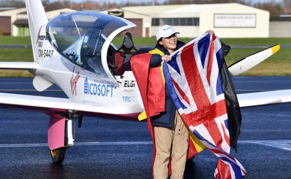 Zara Rutherford, 19, carries the Belgian and British flags on the tarmac after landing her Shark ultralight plane at the Kortrijk airport in Belgium, on Thursday at the completion of a record-breaking solo circumnavigation. Zara Rutherford, 19, carries the Belgian and British flags on the tarmac after landing her Shark ultralight plane at the Kortrijk airport in Belgium, on Thursday at the completion of a record-breaking solo circumnavigation.