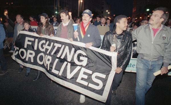 Marchers at a candlelight vigil in San Francisco, Calif., carry a banner to call attention to the continuing battle against AIDS on May 29, 1989. The city was home to the nation's first AIDS special care unit. The unit, which opened in 1983, is the subjec Marchers at a candlelight vigil in San Francisco, Calif., carry a banner to call attention to the continuing battle against AIDS on May 29, 1989. The city was home to the nation's first AIDS special care unit. The unit, which opened in 1983, is the subjec