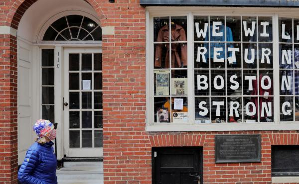 A pedestrian walks past a sign in a shop window in Boston on April 28. The coronavirus crisis has shut down much of economy, leaving millions out of work. A pedestrian walks past a sign in a shop window in Boston on April 28. The coronavirus crisis has shut down much of economy, leaving millions out of work.