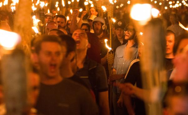 White supremacists march through Charlottesville, Va., the night before the "Unite the Right" rally in August 2017. Federal agents have arrested four men on riot charges connected to the rally. White supremacists march through Charlottesville, Va., the night before the "Unite the Right" rally in August 2017. Federal agents have arrested four men on riot charges connected to the rally.